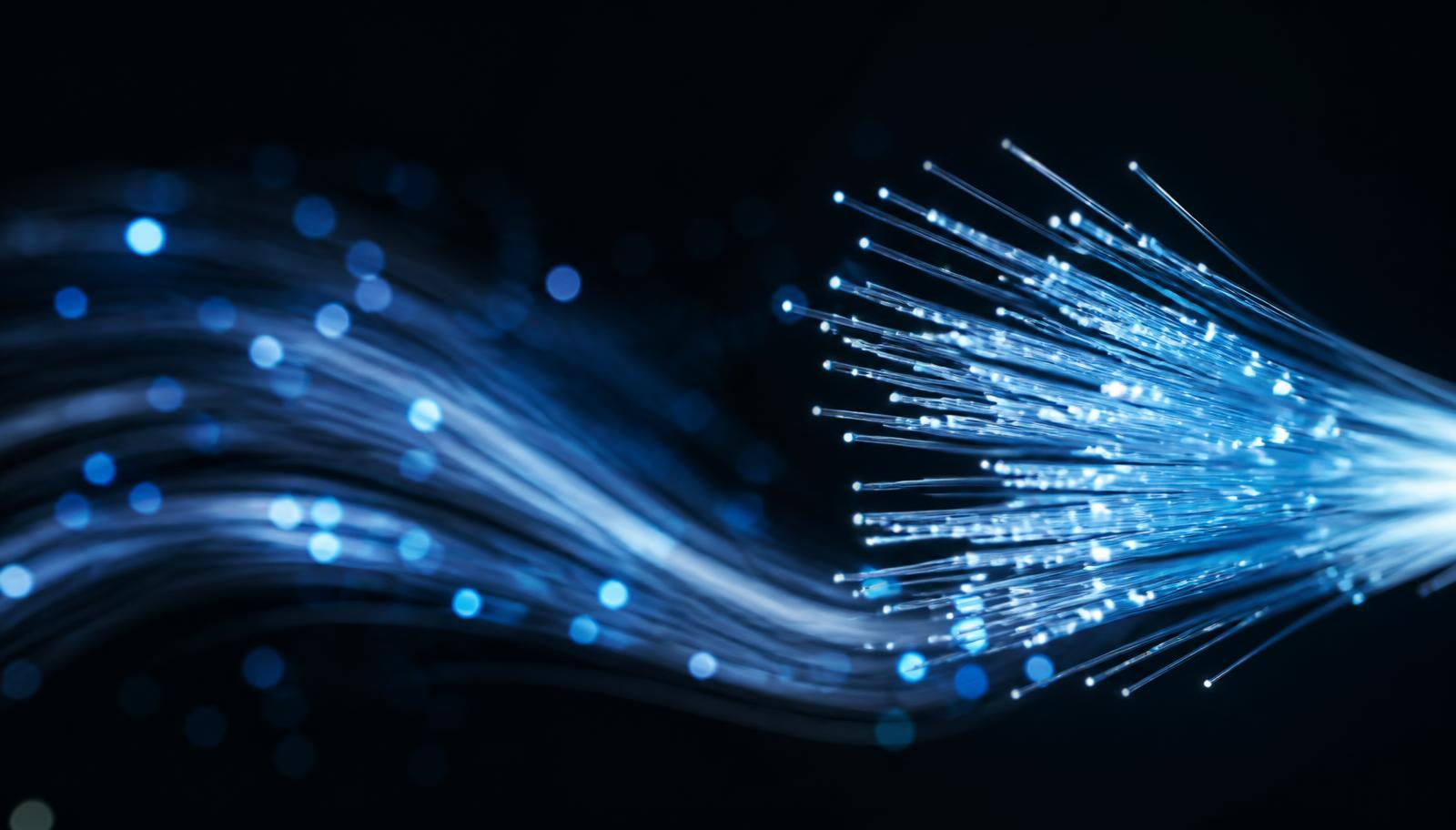 Image représentative de fibres optiques lumineuses illustrant la connectivité numérique